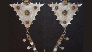 Traditional Amazigh silver fibula displayed on Moroccan textile
